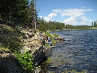 Geologist samples a basaltic lava flow along the Madison River, for 40Ar/39Ar geochronology
