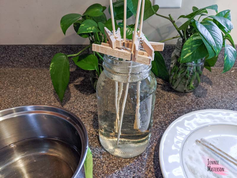 Mason jar filled with rock candy solution. Skewers have been placed inside