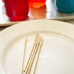 Sugar-coated skewers drying on a plate