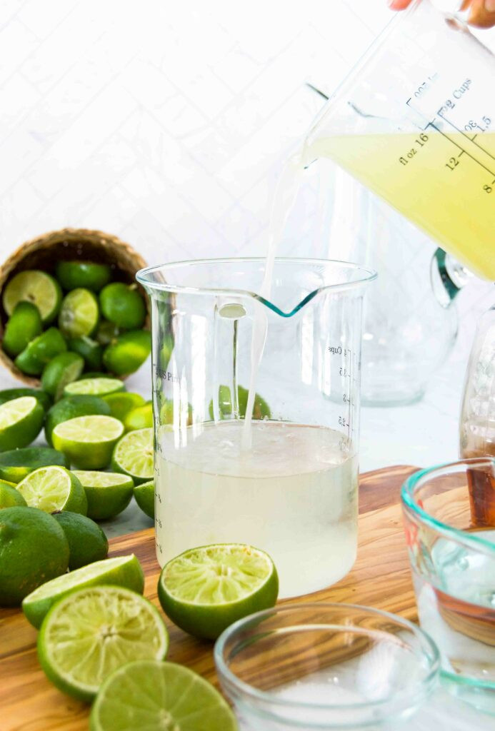 Pouring margarita ingredients into a pitcher