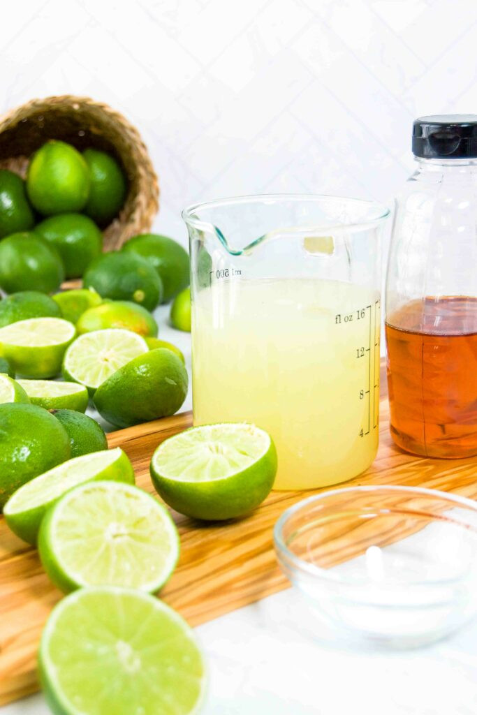 Ingredients for margaritas including limes, tequila, and orange liqueur