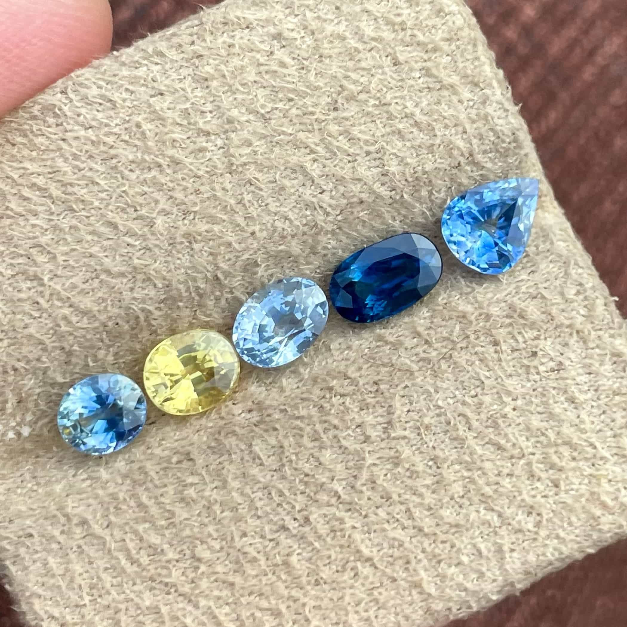 Sapphire gemstone, displaying its range of colors from blue to pink, green, and yellow-orange, sourced from various deposits worldwide.