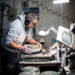 Production Supervisor John Brown hand finishes a stone in the workshop at Kays Curling in Mauchline, south of Glasgow on January 26, 2022. - Kays Curling has been involved in providing curling stones for the Winter Olympics since the Chamonix Games in 1924. The curling stones are made from unique granite rock harvested on Ailsa Craig, an island about 16 kilometres (10 miles) west of the Scottish mainland. (Photo by ANDY BUCHANAN / AFP) (Photo by ANDY BUCHANAN/AFP via Getty Images)