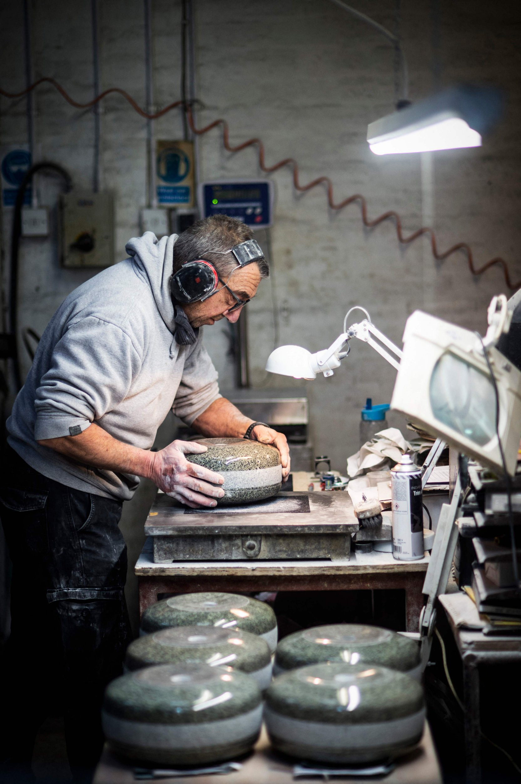 Production Supervisor John Brown hand finishes a stone in the workshop at Kays Curling in Mauchline, south of Glasgow on January 26, 2022. - Kays Curling has been involved in providing curling stones for the Winter Olympics since the Chamonix Games in 1924. The curling stones are made from unique granite rock harvested on Ailsa Craig, an island about 16 kilometres (10 miles) west of the Scottish mainland. (Photo by ANDY BUCHANAN / AFP) (Photo by ANDY BUCHANAN/AFP via Getty Images)