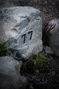Outdoor metal sign on a natural rock, showcasing effective landscape integration