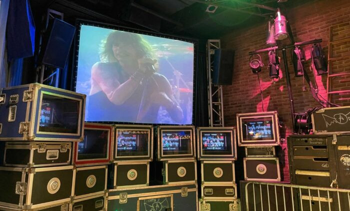 Aerosmith working at the mixing board to fine-tune a recording on Rock 'n' Roller Coaster Starring Aerosmith