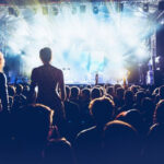 Outdoor rock concert with a crowd of people enjoying the music, showcasing the energy of the performance
