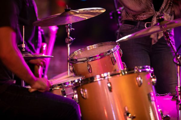 A close-up shot of rock drums being played with intensity, highlighting the instrument's contribution to the loudness of a rock concert