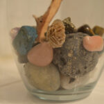Rock collection display in a glass vase with a manzanita branch, showcasing a simple yet elegant decorative element for a bathroom counter.
