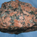 Granite with pink-reddish feldspar, black mafic minerals, and grey quartz