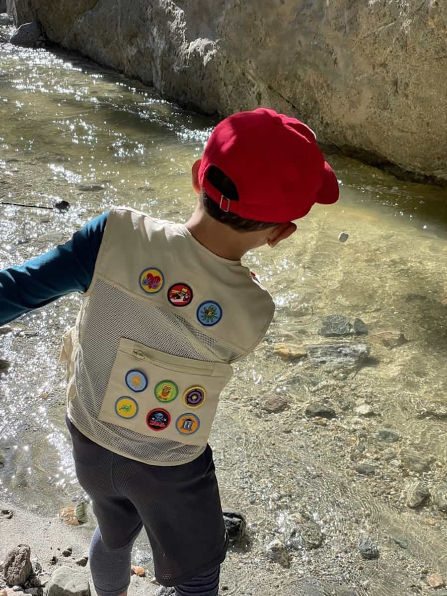Child skipping stone in water, showing a young person enthusiastically engaged in the activity, with a focus on the action of throwing and the resulting splash