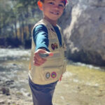 Child holding a stone for skipping, emphasizing its flat shape and comfortable grip