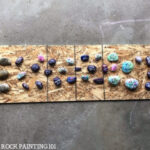 Spacing painted rocks for even sealant coverage, essential for weather protection