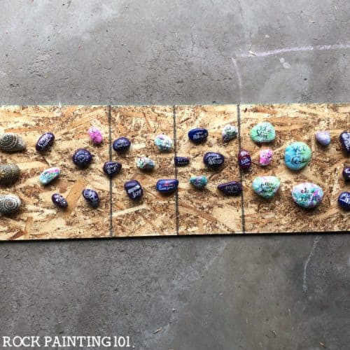 Spacing painted rocks for even sealant coverage, essential for weather protection