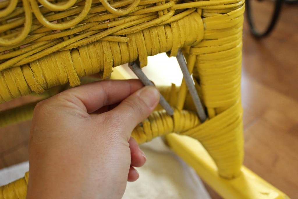 Using tools to carefully weave and repair damaged wicker