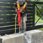 Jackhammer breaking concrete for landscaping preparation