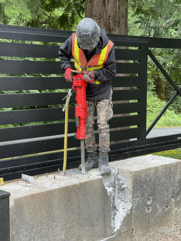 Jackhammer breaking concrete for landscaping preparation