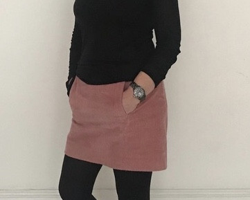 A woman with her hands in the pocket of her skirt 