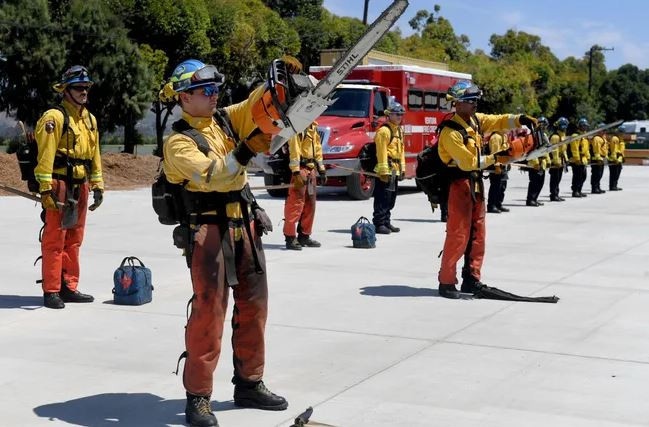 Fire fighters demonstrate how to safely hold a chain saw