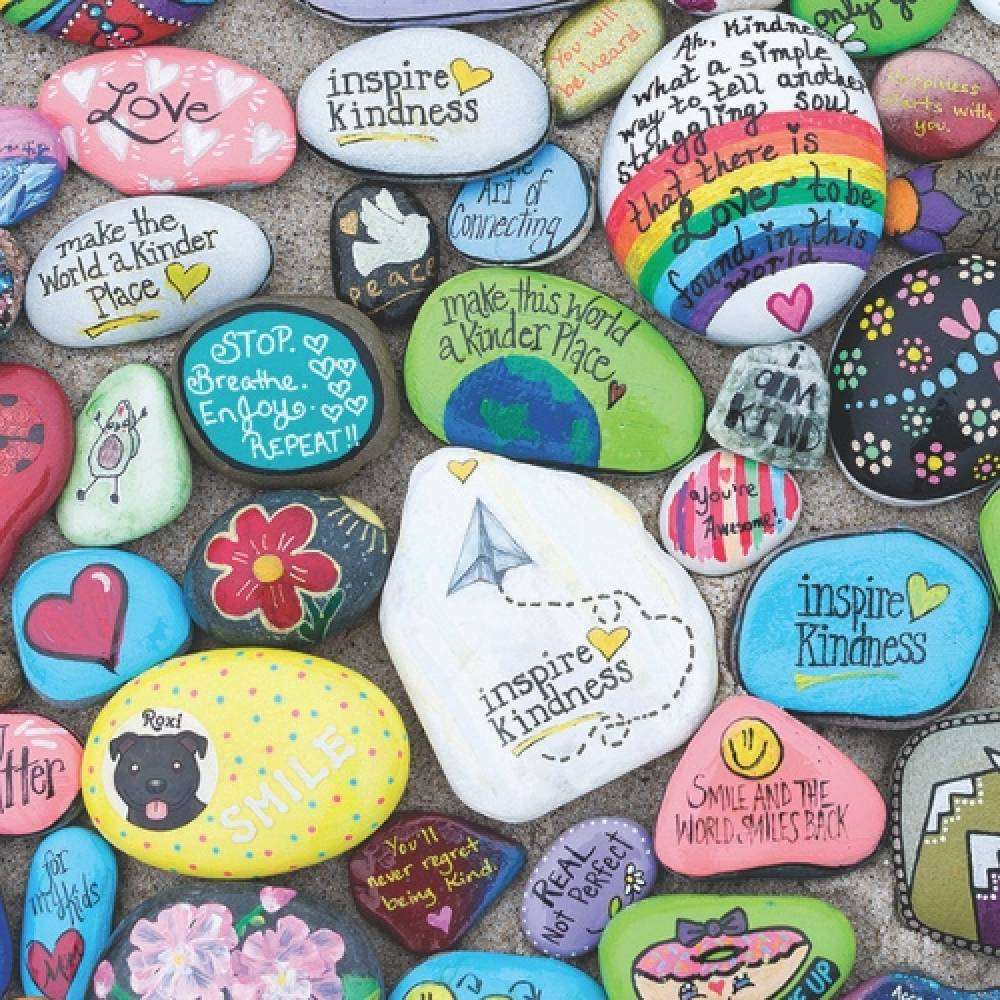 Assortment of colorful painted rocks displayed on a mossy surface, perfect for outdoor decoration