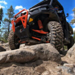 Factory UTV UHMW Skid Plate protecting the underside of a Can-Am Defender XT-P, essential for rock crawling.
