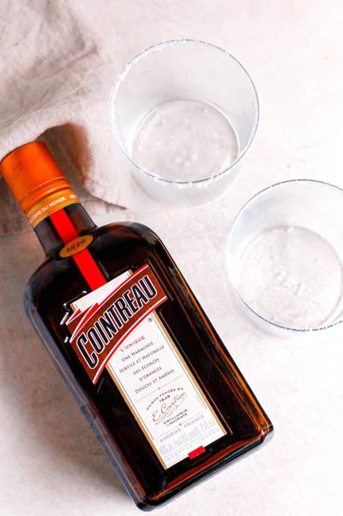 Bottle of cointreau next to glasses