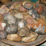 Fairburn agates in a wooden bowl, showcasing sensuality and vibrant energy.